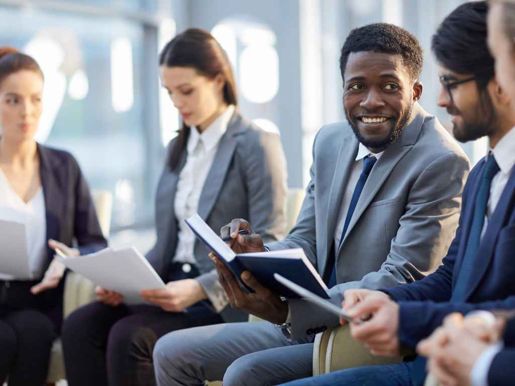 Diverse team in a meeting discussing policies for a new jersey employee handbook.